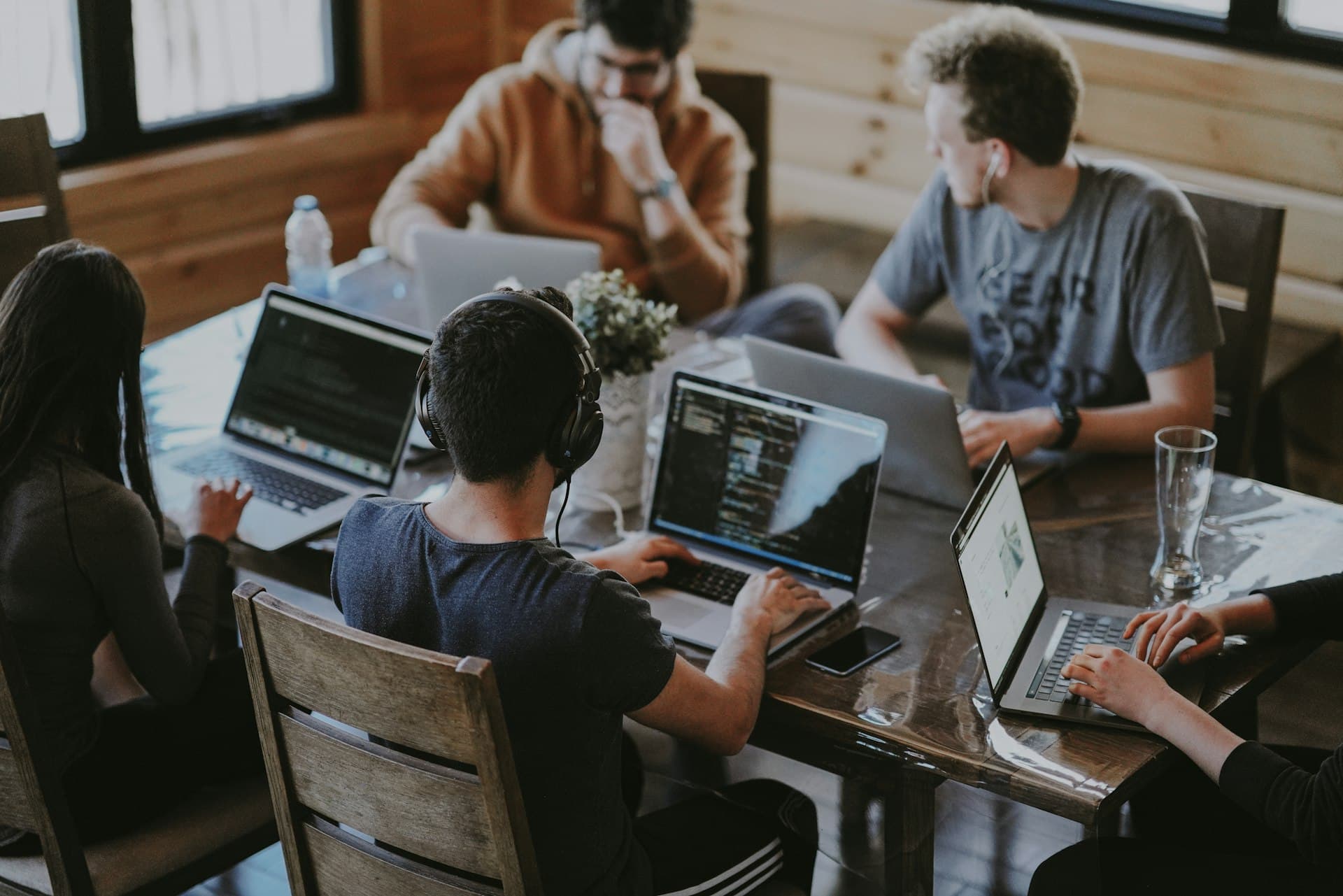 People collaborating around a table with laptops